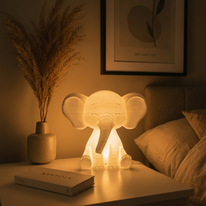 Decorative elephant lamp on a bedside table with a book and plant in a warm, cozy room.