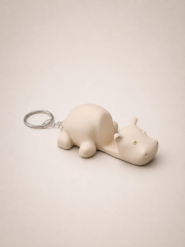 White hippo-shaped keychain on a beige background