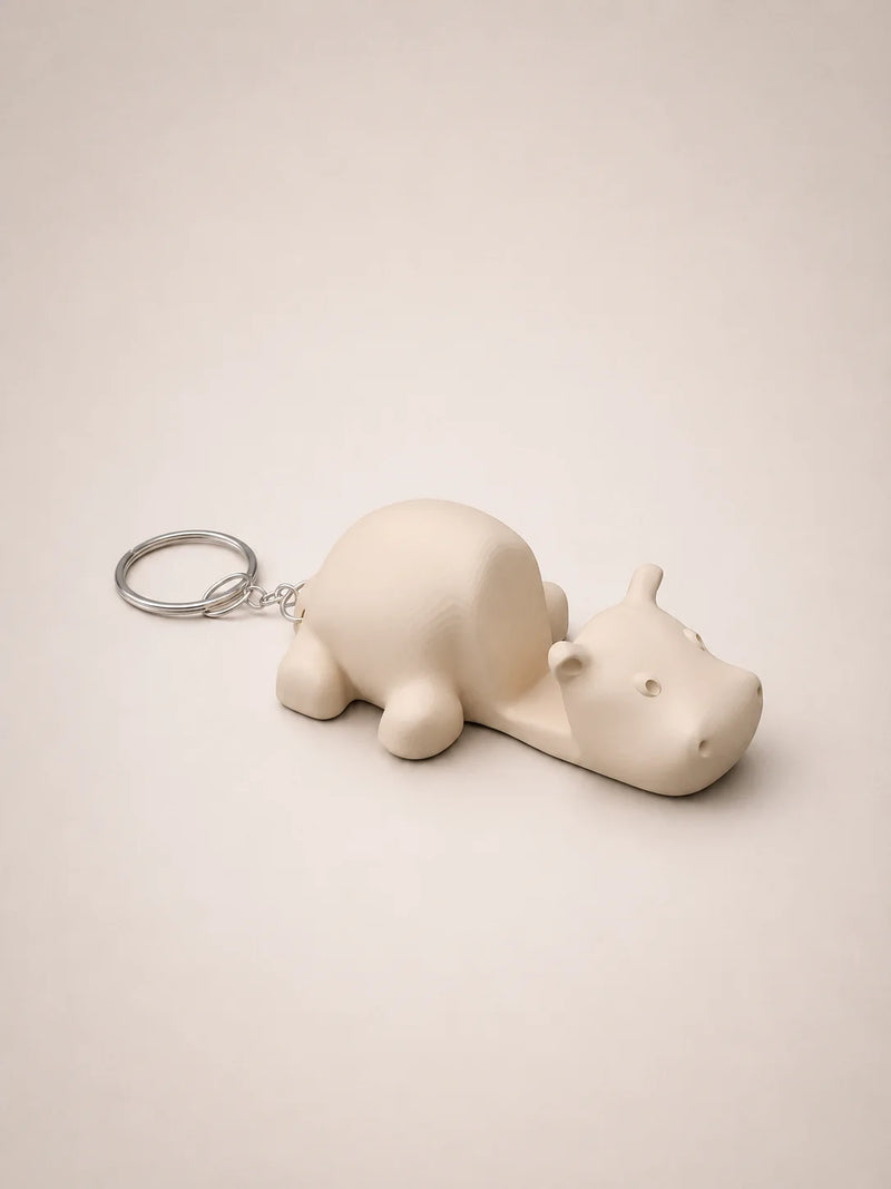 White hippo-shaped keychain on a beige background
