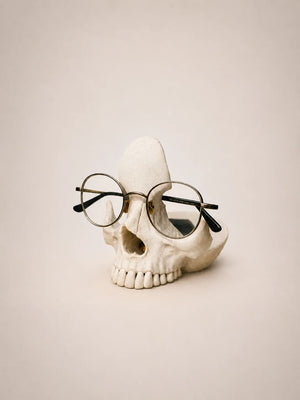 Skull with round glasses on a beige background