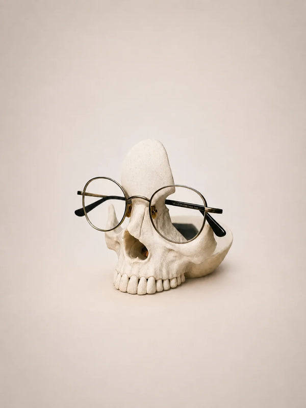 Skull with round glasses on a beige background